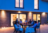 Familie sitzt am Abend auf der Terrasse